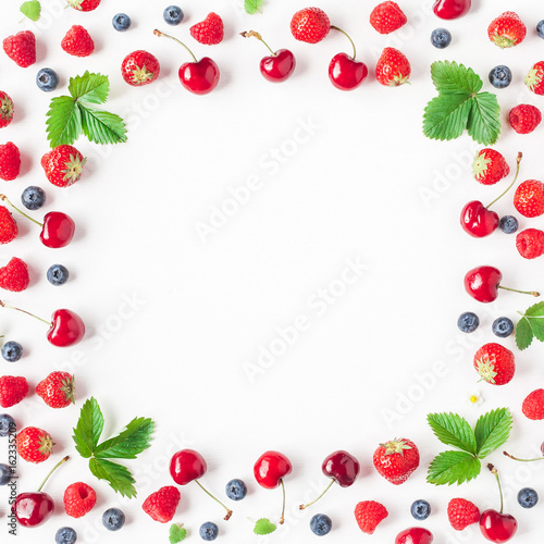 Fruits on white background. Creative frame made of fresh fruits. Strawberry, raspberry, blueberry and sweet cherry. Summer concept. Flat lay, top view, copy space