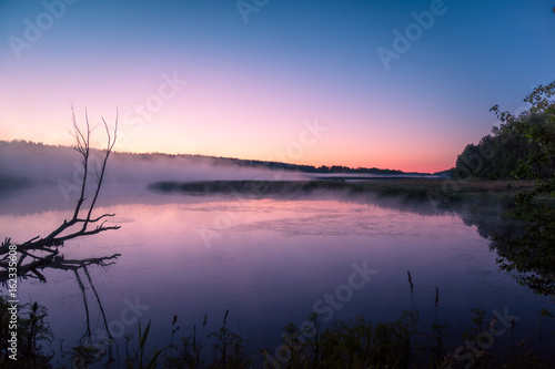 Foggy morning. Lake before sunrise. Rural landscape  mystical feeling