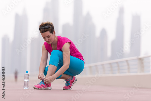 woman tying shoelaces on sneakers