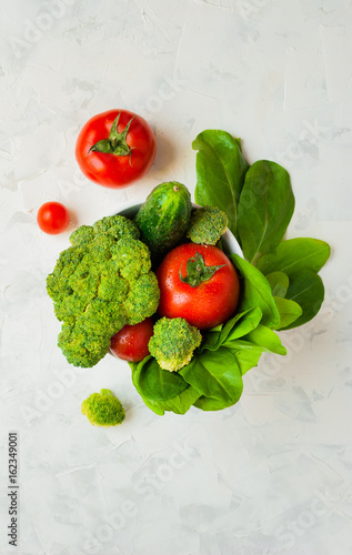 Lettuce leaves, cherry tomatoes, cucumber and broccoli on white background.