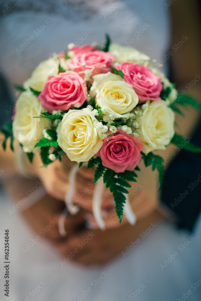 the bride holding a bouquet of multicolored roses the bride holding a bouquet of multicolored roses