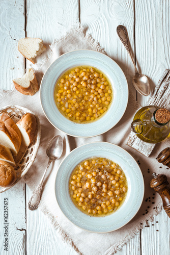 Greek chickpea soup in the white wooden table top view photo