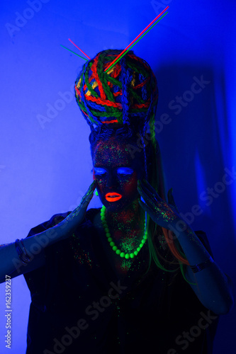 luminous portrait of a girl in the UV rays on white background