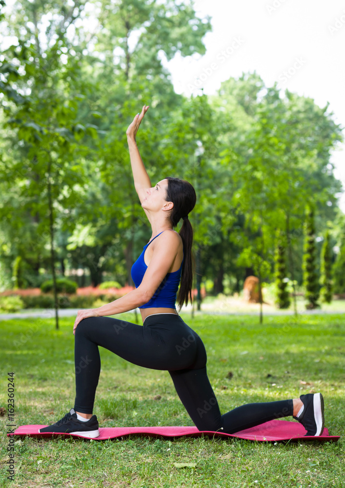 Fototapeta premium young fitness woman exercise in a park in summer