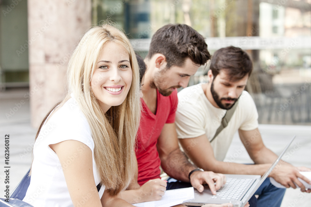 Group of university students using laptop together Group of university students using laptop together