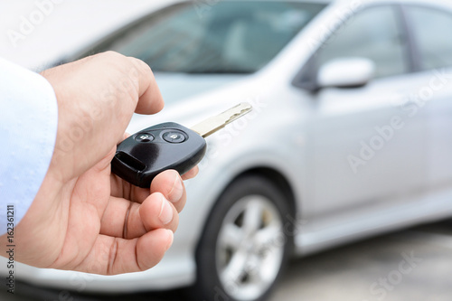 A man hand about to press button of remote control car key
