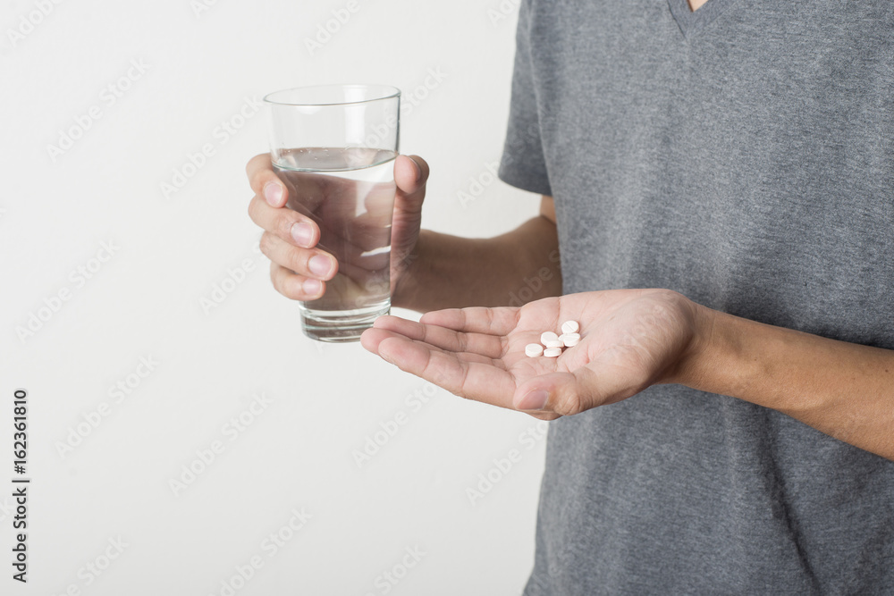 young man taking pill on white background young man taking pill on white background