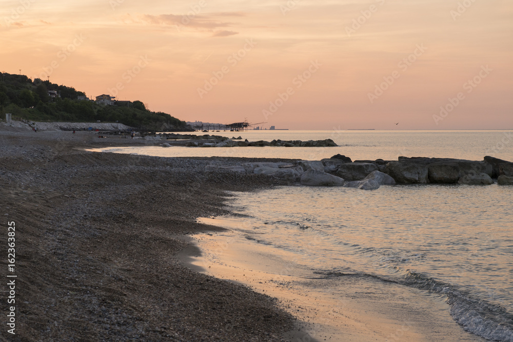 Frangiflutti sulla costa adriatica al tramonto