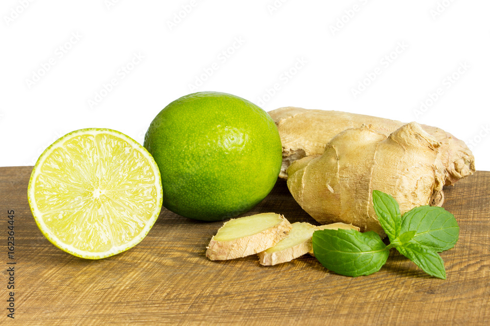 detail of whole and cut fresh ginger with lime
