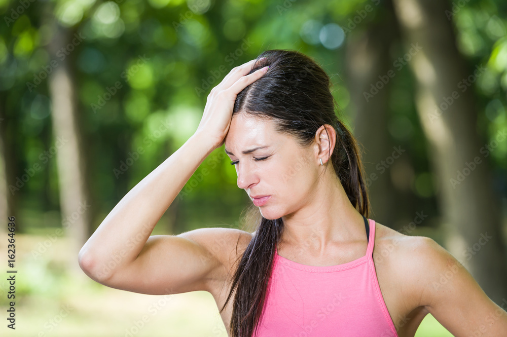 fitness woman headache in a park