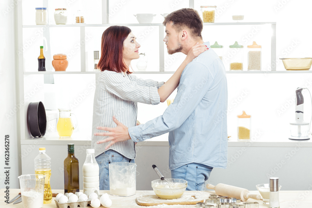 Funny Couple in love cooking dough and having fun with flour in kitchen Funny Couple in love cooking dough and having fun with flour in kitchen