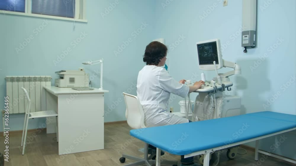 Woman doctor working at ultrasound diagnostic machine Woman doctor working at ultrasound diagnostic machine
