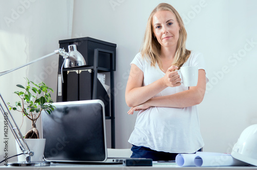 Blonde architect is making amendments in her project photo