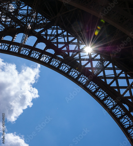 Sun shining through Eiffel Tower. Colorful beams and spots. Paris (France)