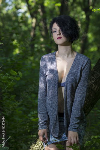 Pretty young girl posing outdoor in a forest