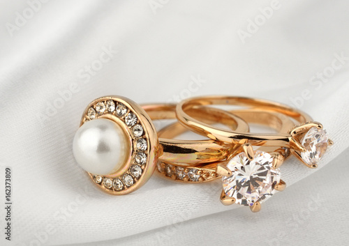 jewelry rings with diamonds and pearl on white cloth, soft focus