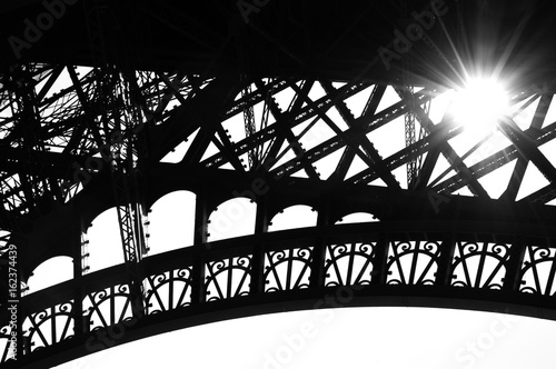 Sun shining through Eiffel Tower. Colorful beams and spots. Paris (France). Black and white.