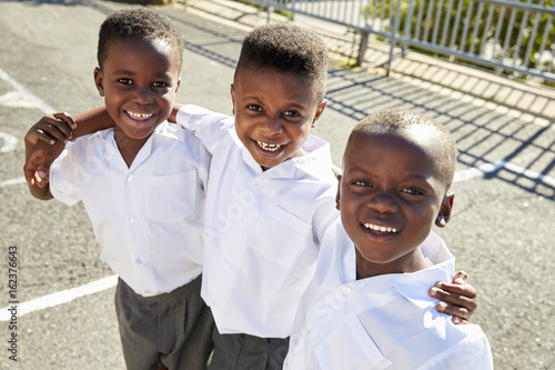 Young African schoolboys smiling to camera in a playground photo