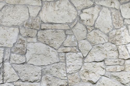 Wall made of natural limestone. Irregular stone surface.
