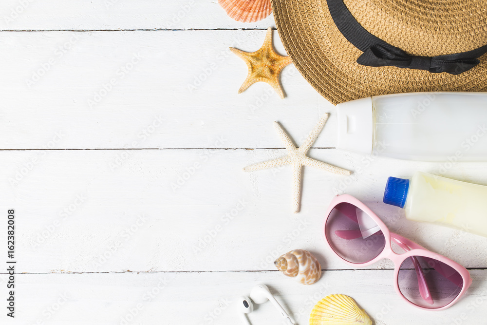 Naklejka premium Beach accessories. Bag, towel, sunglasses and flip-flops on wooden background. Top view with copy space