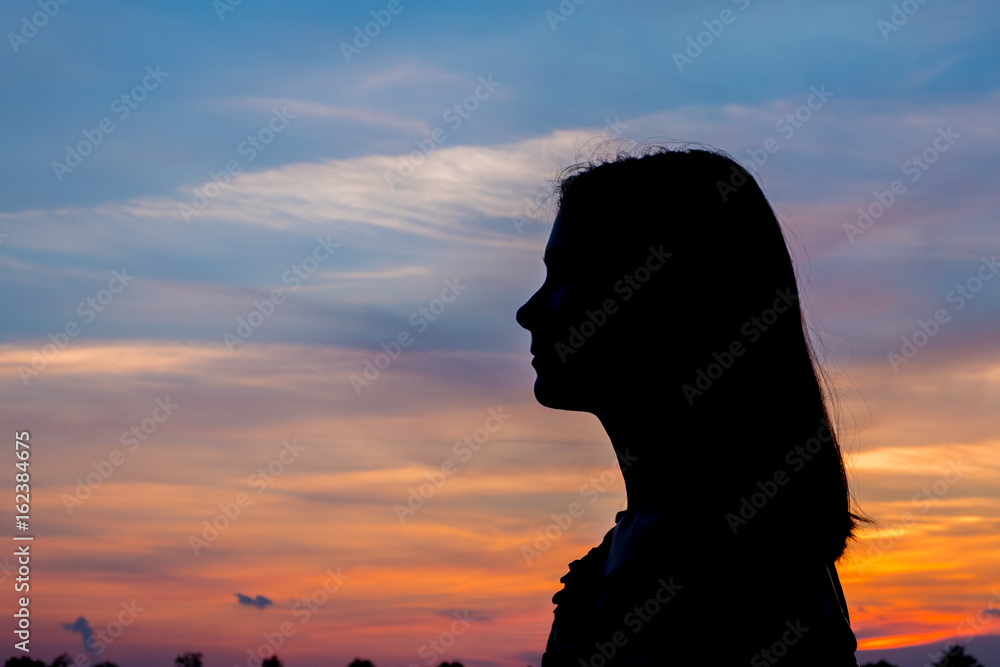 Girl enjoys the sunrise with a view of the beautiful sky. Portrait in profel. Girl enjoys the sunrise with a view of the beautiful sky. Portrait in profel.