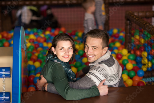 young parents with kids in a children's playroom photo