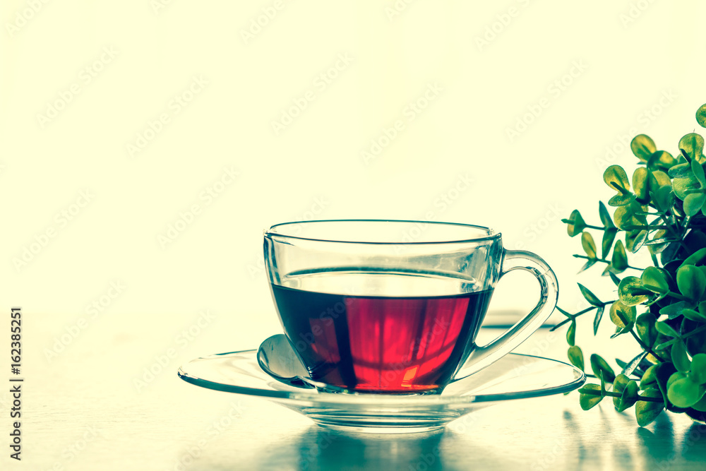 Close up the warm black tea cup on the wooden table in living room , relax with tea time concept Close up the warm black tea cup on the wooden table in living room , relax with tea time concept
