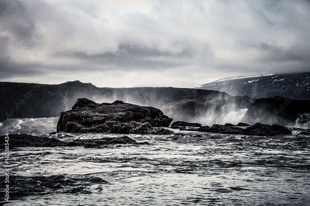 Water of the Godafoss Waterfall - beautiful part of stony rocky desert landscape of Iceland. Toned