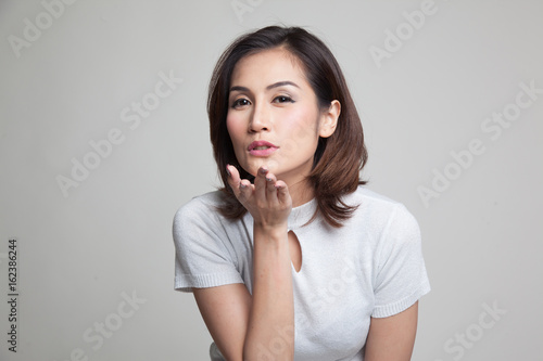 Beautiful young Asian woman blow a kiss.