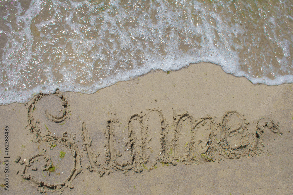 Inscription summer on a sandy beach and sea wave Inscription summer on a sandy beach and sea wave