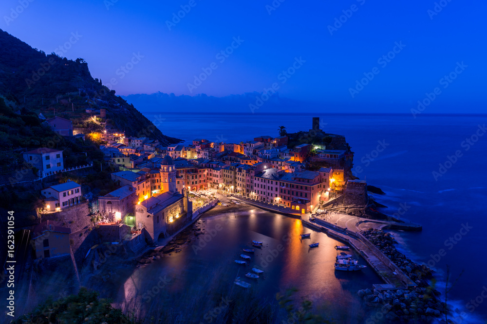 view of famous travel landmark destination Vernazza, small mediterranean old sea town with harbour coast and castle,Cinque terre National Park, Liguria, Italy. Summer clear night with street lights