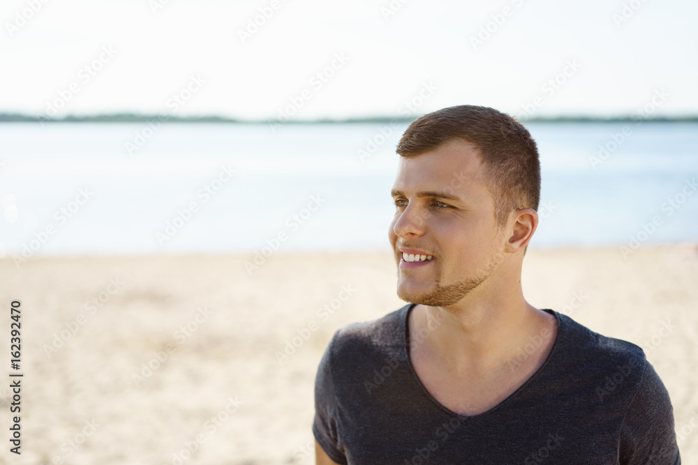 Smiling young man relaxing on a beach Smiling young man relaxing on a beach
