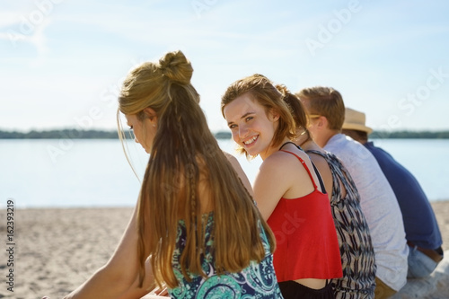 Young friends relaxing in a group at the seaside