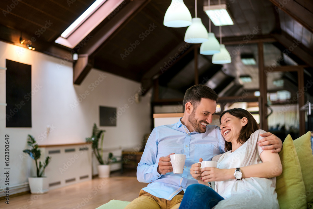 Photo of a family couple sitting on the sofa at home and spending their free time together Photo of a family couple sitting on the sofa at home and spending their free time together