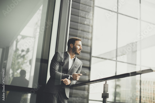 Canvas Print Young successful men entrepreneur using mobile phone outdoor