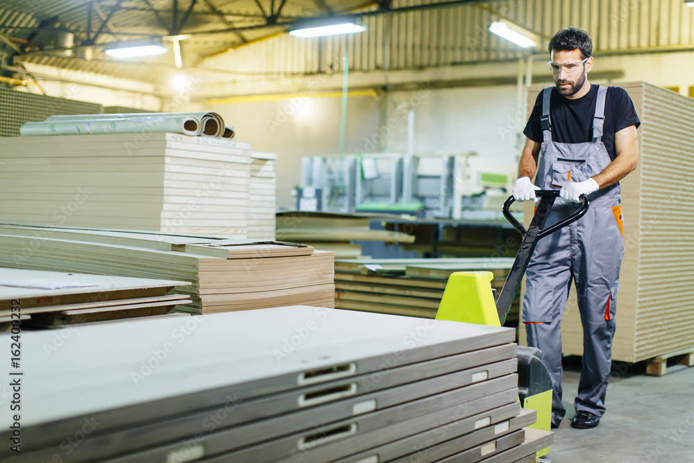 Handsome young man working in the furniture factory Handsome young man working in the furniture factory