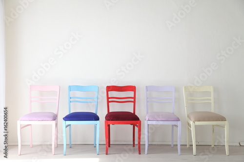 White room with colorful chairs blue yellow red blue purple