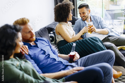 Group of friends watching TV, drinking cider  and having fun © BGStock72