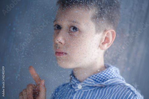 Boy behind the window photo