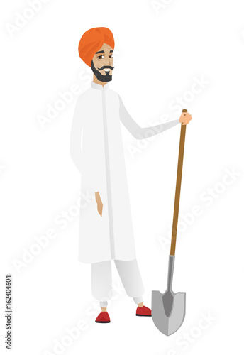 Young hindu farmer holding a shovel.