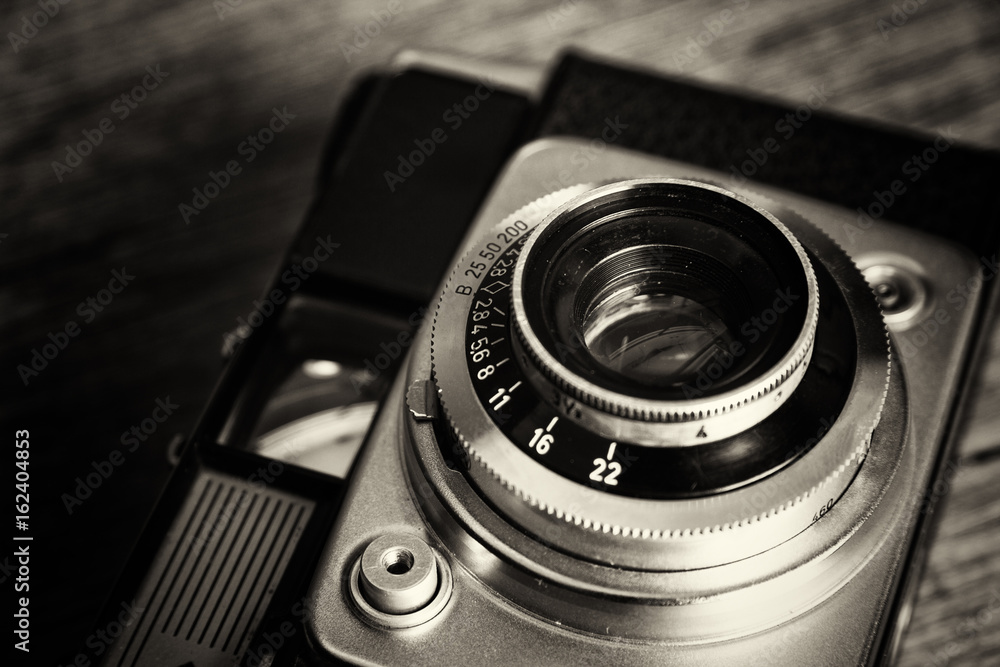 Old vintage retro camera on wooden background