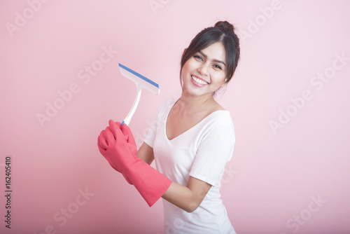 Beautiful asian housewife smiling on pink background