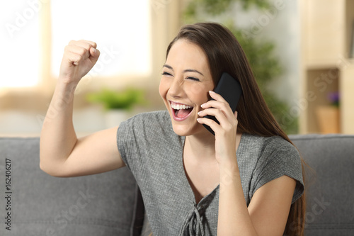 Excited woman listening news on the phone