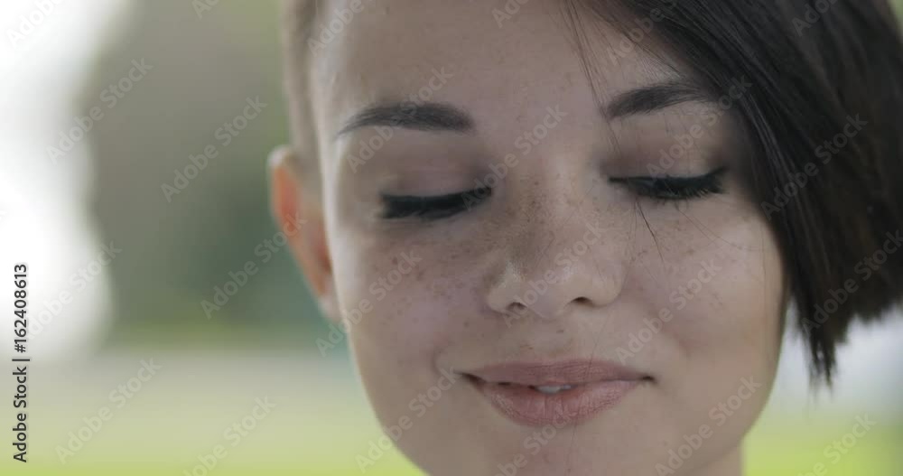 Pretty woman closeup portrait looking to camera at summer day. Beautiful female face. Pretty woman closeup portrait looking to camera at summer day. Beautiful female face.