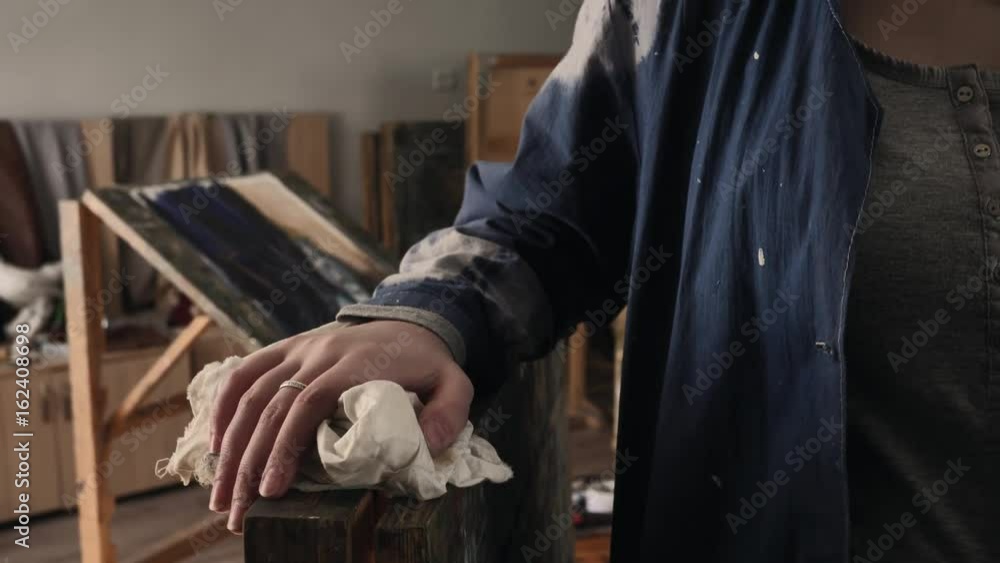 Shot of a young woman working in messy studio painting on a canvas Shot of a young woman working in messy studio painting on a canvas