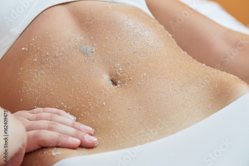 Body Scrub. Beautiful Blonde Gets a Salt Scrub Beauty Treatment in the spa Salon