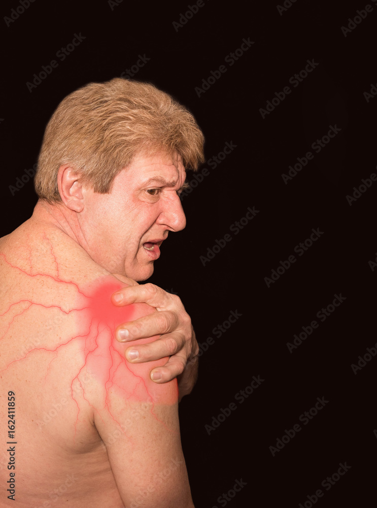 Obraz premium Close-up of senior shirtless man with shoulder pain over black background