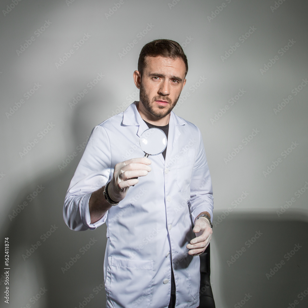 Doctor in a white coat holding in his hand a magnifying glass Doctor in a white coat holding in his hand a magnifying glass