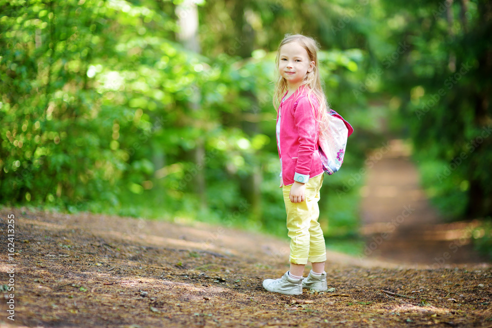 Cute little girl having fun during forest hike on beautiful summer day Cute little girl having fun during forest hike on beautiful summer day