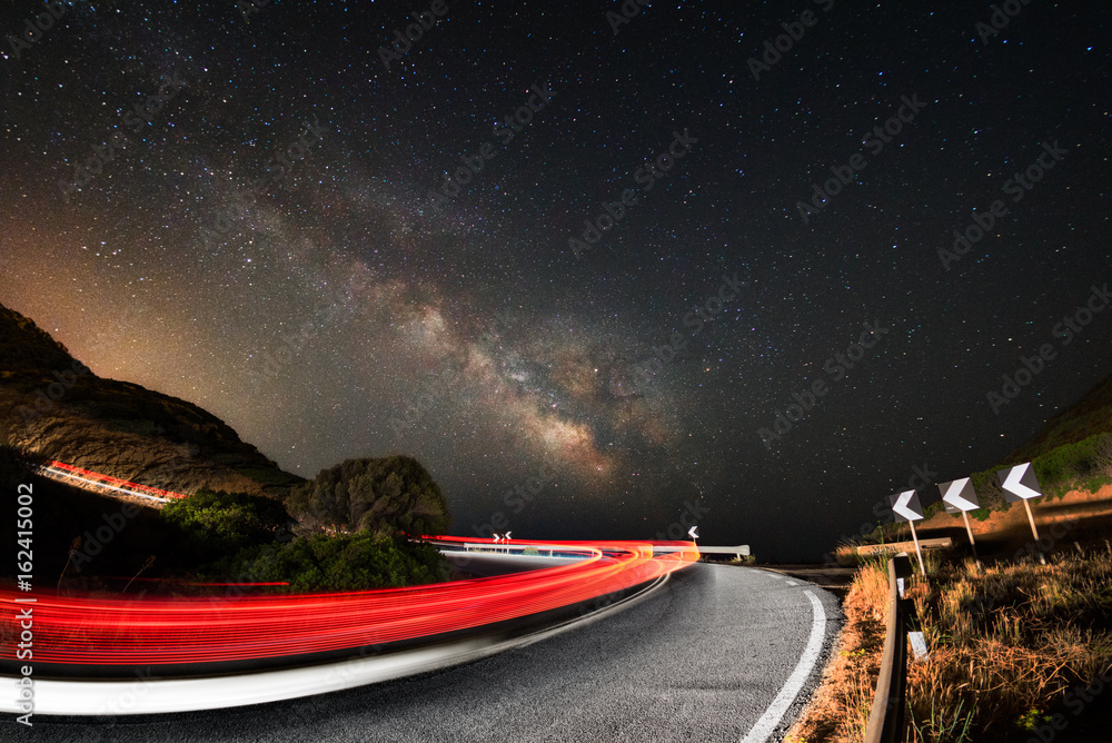 Light trails on the road with the milky way galaxy in background Stock ...